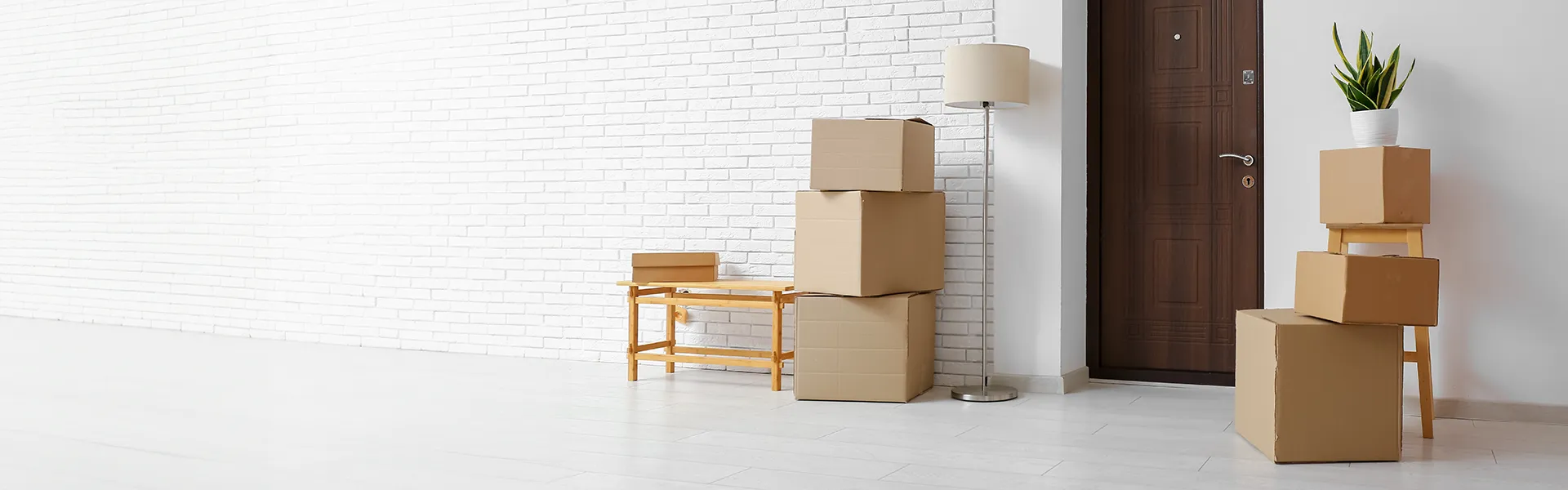 Kartonboxen mit Lampe im Zimmer am Tag des Umzugs