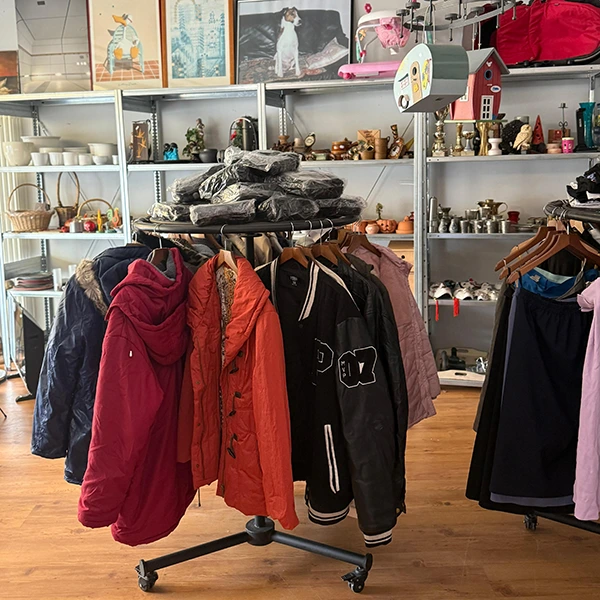 Kleiderständer und im Hintergrund Regale mit Second Hand Ware